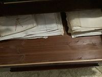 Folded embroidered linens with lace on a wooden surface