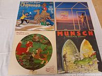 Four kids' LP records on a white cloth background: Chipmunks, Raffael Wand Shine, The Fox and the Hound, and Munsch Favourite Stories.