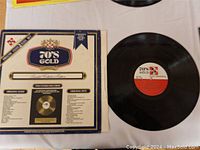 Two 70's Gold vinyl records and original album cover sleeve laid out flat on white surface.