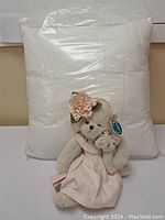 Large white pillow with one larger and one smaller teddy bear in front.