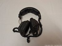Photo of black over-ear headphones showing padded headband and coiled wire.