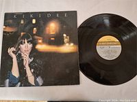 Full view of Kikidee vinyl LP record and its album cover laid out flat on white surface.