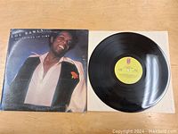 Lou Rawls 'All Things in Time' LP record partially pulled out from sleeve showing yellow label and reflective vinyl surface.
