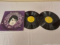 Double LP vinyl records and album cover sleeve for Neil Diamond's 'The Diamond's'. Records black with yellow labels, album cover purple with diamond and portrait graphics.