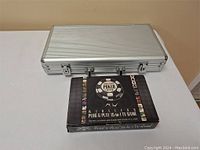 Closed silver aluminum case beside boxed Wireless TV game