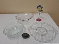 Overview of vintage glass serving pieces including three bowls, segmented tray, decorative egg, and painted wine glass.