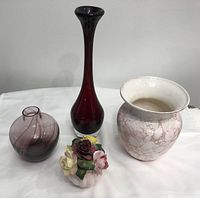 Photo showing all four items grouped: tall burgundy glass vase, round Caithness glass vase with white and burgundy stripes, mottled pink and white vase, floral china rose arrangement