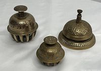 Front angle showing the large and small claw foot bells along with the teachers bell, detailing ornate engravings and button handles.