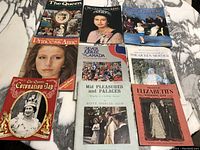 Photo showing all vintage royalty magazines and books spread on marble surface, titles visible including Princess Anne, The Queen, Silver Jubilee Canada, Princess Elizabeth's Wedding Day, and more.