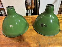 Two green enamel light shades side by side showing the exterior surface