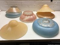 Eight assorted decorative glass lamp shades, showing variety in color and texture.