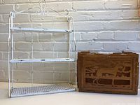 Photo showing the metal folding wall shelf and wooden magazine holder side by side against a brick wall.