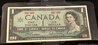 Front side of the 1967 Canadian one dollar banknote showing the portrait of Queen Elizabeth II and text marking the Centennial.