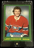 Front side of 1973-74 Larry Robinson hockey card showing color image of player in Canadiens uniform with green border and card info.