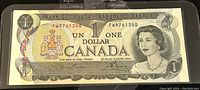 Front view of the Canadian 1 dollar 1973 paper banknote showing Queen Elizabeth II portrait, serial number, and coat of arms.