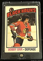 Front of the hockey trading card in protective case showing Bobby Orr in Black Hawks uniform.