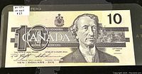 Front view of 1989 Canadian $10 banknote featuring Sir John A. Macdonald's portrait with denomination 10, signature, and detailed architectural background.