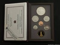 Open brown display folder showing six coins including the special silver dollar and certificate of authenticity.