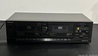 Front view of the Technics RS-T16 double cassette deck showing both cassette compartments, button controls, and brand name.