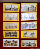 Top view of 10 antique stereoscope cards laid out in two columns of pairs showing mostly Paris landmarks and two cards showing German architecture, yellow and white borders.