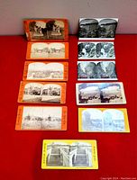 Full lot laid out showing 11 stereoscope viewer cards with various colored borders showing black and white outdoor scenery images.