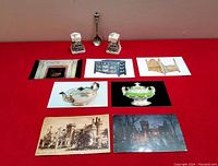Overview of the entire lot showing a set of ceramic salt and pepper shakers, a silver souvenir spoon, six vintage postcards, and one antique WW2 era postcard, all related to Casa Loma Toronto.