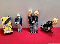 Photo showing three ceramic wine bottle holders shaped as butlers and the original box for one holder