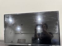 Front view of 28 inch LG smart TV showing screen, reflective with smudges, LG logo visible.