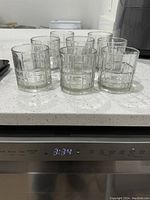 Eight small crystal glasses grouped on a white countertop showing the square grid pattern.
