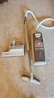 Full view of the vintage Electrolux canister vacuum with attached hose and chrome wand, plus the Omni-Flo automatic cleaning head on carpet