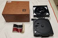 Photo showing Kodak leather carry case, Kodak Carousel slide projector manual, Slide carousel tray, and slide projector base unit
