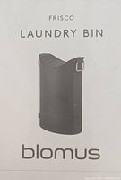 Photo of the front of the packaging showing the Blomus Frisco Laundry Bin product image and branding.