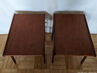 Top-down view of both rectangular teak tabletops with raised edges