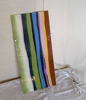 Front view of vintage IKEA Gyllen wall sconce showing colorful striped glass panel surface.