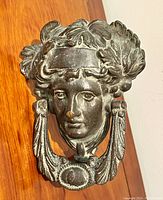 Front view showing detailed Liberty head with laurel leaves and ring knocker.