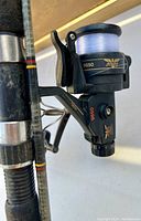 Close-up of Fenwick 9650 spinning reel attached to fishing rod, showing logo, model number, line spool and crank handle.