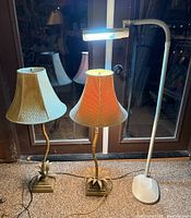 Photo showing Ott-Lite adjustable floor lamp with white base and two matching palm tree style table lamps with fabric shades, cords visible