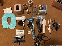 Lot contents with hair styling tools, heated neck wrap, hair rollers, and bathroom holders all displayed.