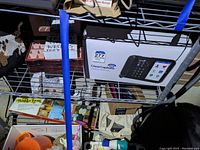 Shelf with boxed ClearCaption phone, decorative pillows, and wooden jewelry box