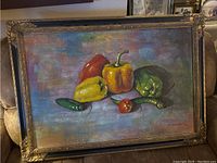 Frontal view of oil painting showing colorful peppers and artist signature T. Denver in gold and black frame.