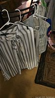 Striped blouse from White House Black Market, denim vest, and other hanging tops visible on hangers on a rack