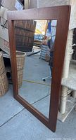 Full view of wood frame mirror with clear reflection and smooth corners