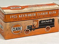 Close-up of original sealed box with vintage style graphics and orange and white coloring for 1925 Kenworth Tanker Bank by Clark. Shows condition of box and branding.