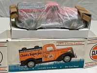 Front and top view of Clark Oil branded 1937 Chevy tank truck 1:25 scale die cast metal lockable coin bank inside original open box packaging, wrapped in clear protective plastic with cardboard supports