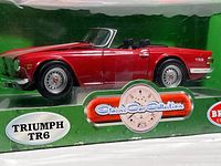 Close up photo of detailed red Triumph TR6 model car inside packaging showing scale & product branding