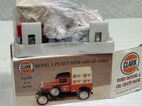 Clark Model A pickup bank box with illustration of the Clark Model A oil truck bank, part of a limited series, showing front and side of box.