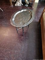 Metal tray top with scalloped edges and textured finish, positioned on the wooden base.