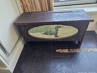 Front view of the solid wood storage box showing the duck inlay on the front panel and the textured wood surface.