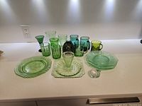 Overview of all 19 assorted green glassware pieces including plates, glasses, mugs, bowls, and a pitcher.