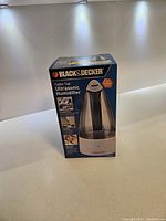 Front view of boxed Black & Decker Table Top Ultrasonic Humidifier showing product image and branding.